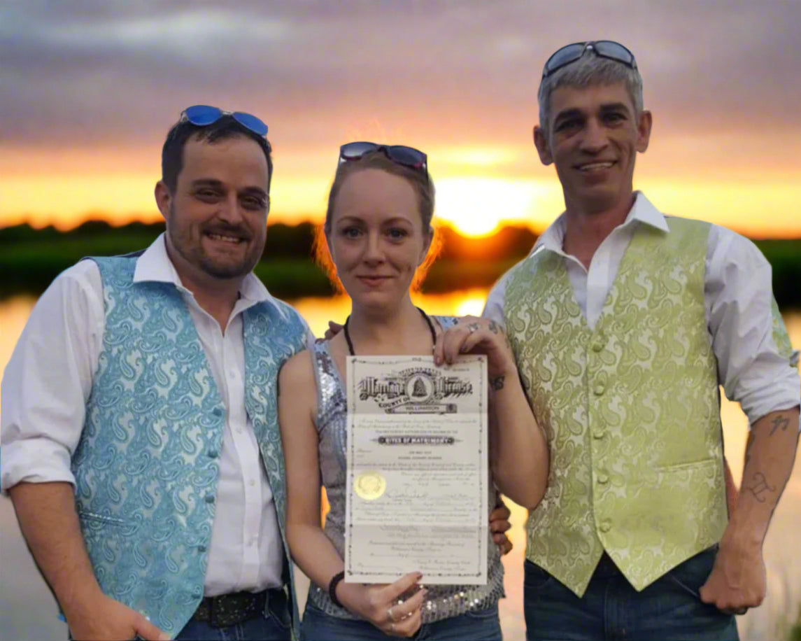 Three people standing outdoors with a woman holding a certificate.